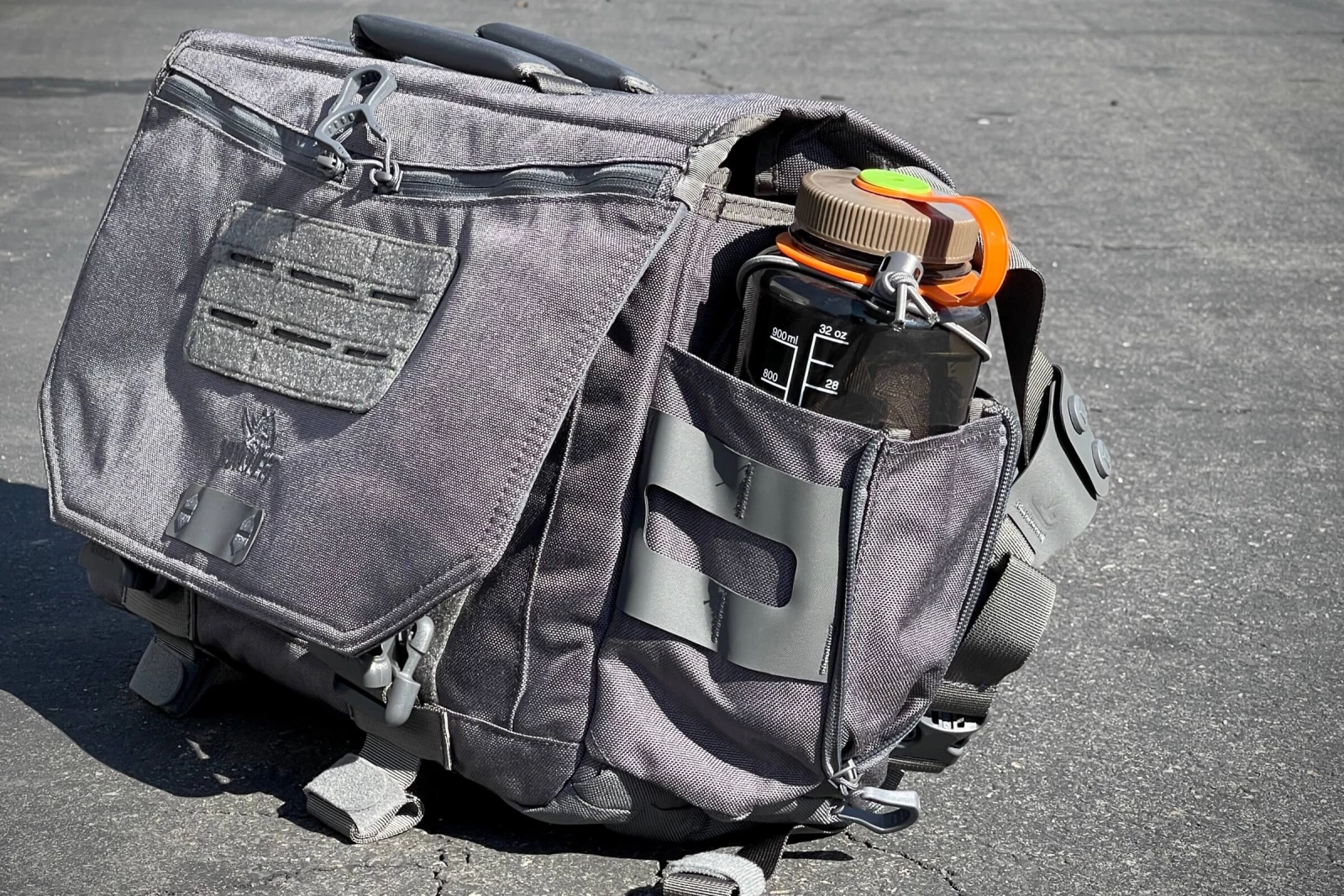 Side water bottle carry for messenger and sling bags.